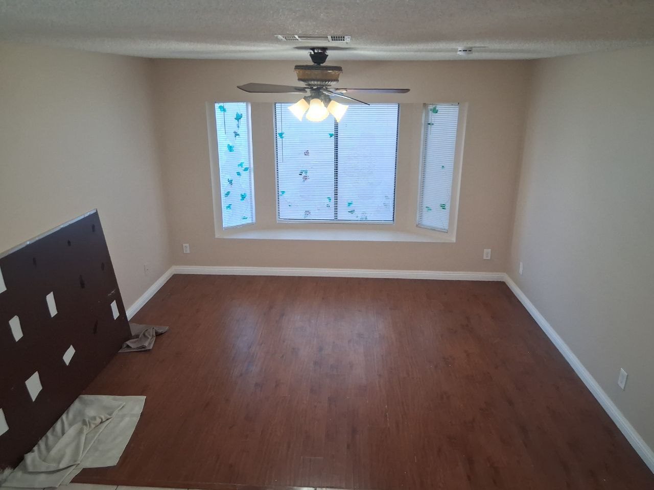 Living room with a new floor and a ceiling fan
